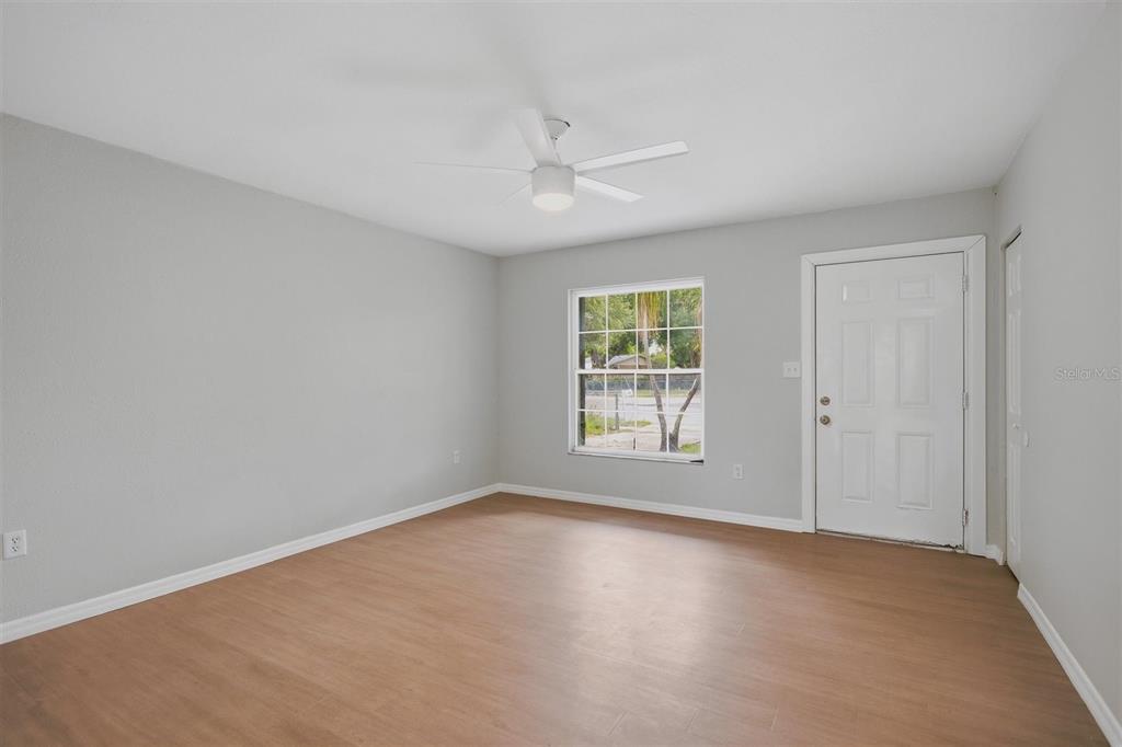 An empty room with light gray walls, wood-look flooring, a ceiling fan, and a door — 322 LITTLE ROCK COURT, OCOEE, FL