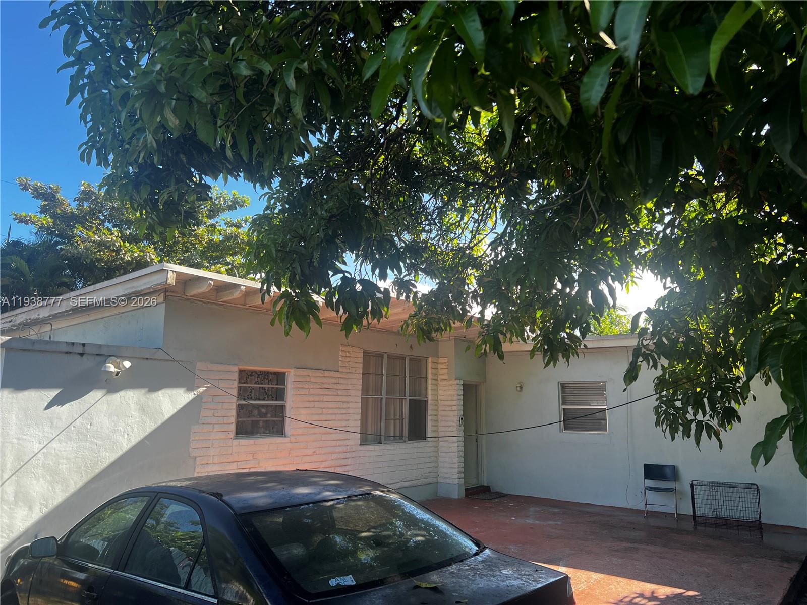 A single-story house with a flat roof, white exterior walls, and a paved driveway — 289 NW 109th St, Miami FL 33168, MIAMI, FL