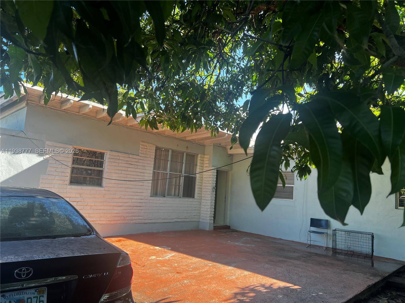 A single-story house with a brick facade and a paved driveway under a tree — 289 NW 109th St, Miami FL 33168, MIAMI, FL