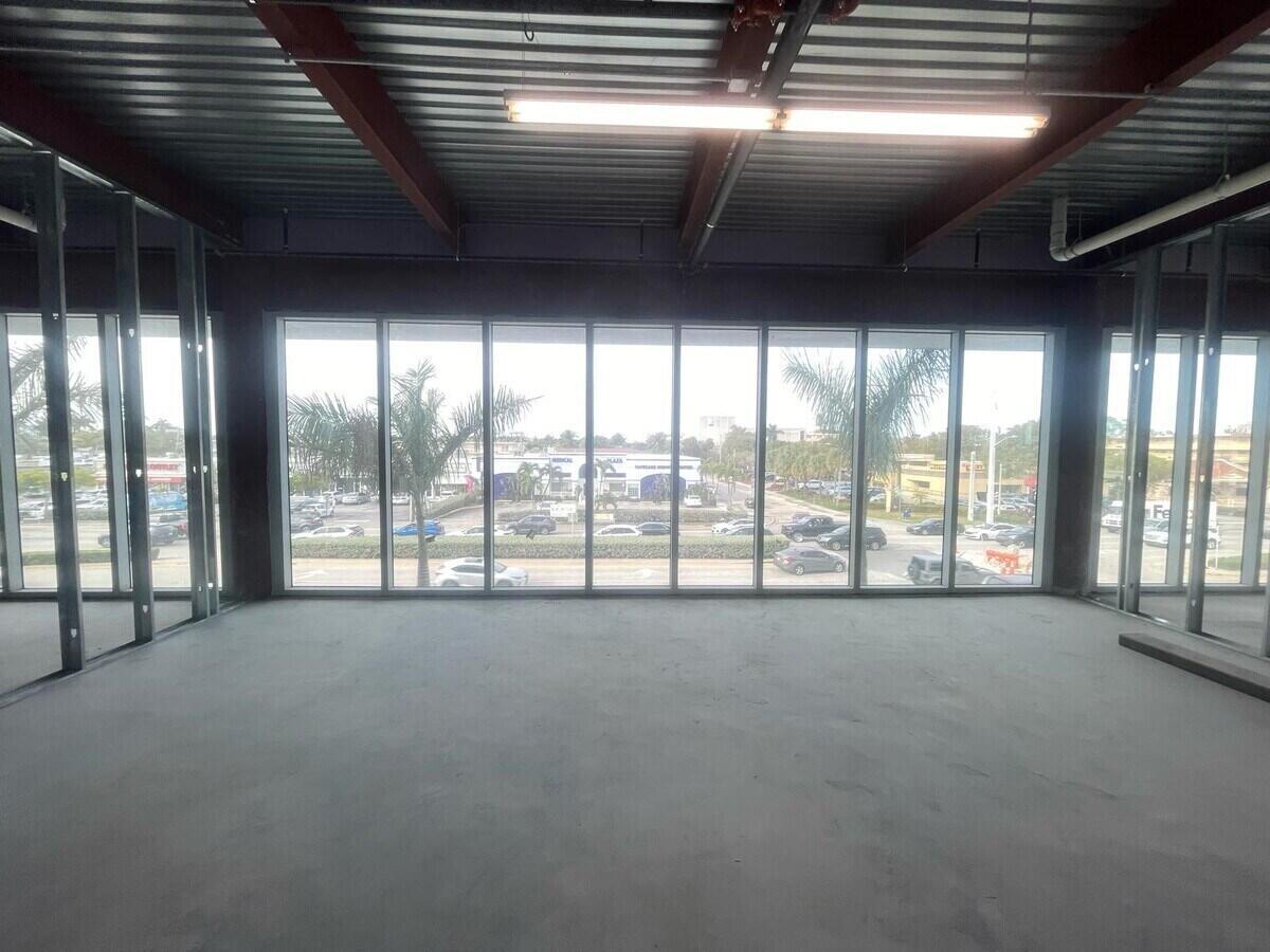 An unfinished commercial interior space features metal wall framing, concrete flooring, and large floor-to-ceiling windows — 1000 E Hallandale Beach Boulevard # 103, Hallandale Beach FL 33009, HALLANDALE BEACH, FL