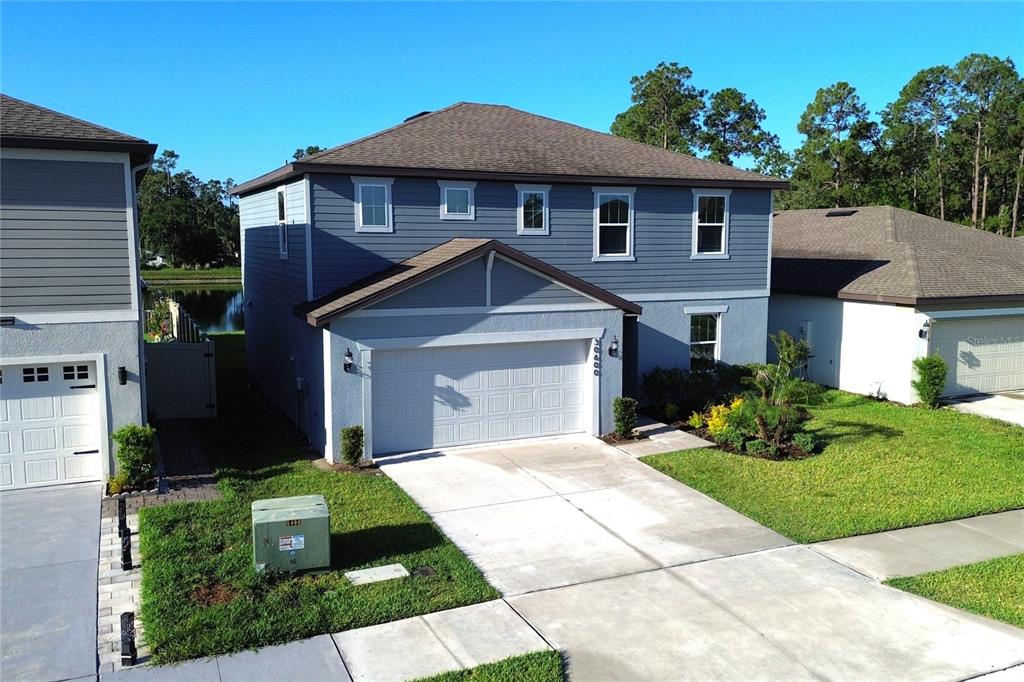 An aerial view of a two-story blue house with a two-car garage and driveway — 30600 THUNDERBIRD DRIVE, WESLEY CHAPEL, FL