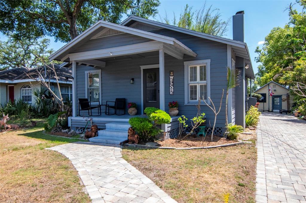 A gray bungalow with a front porch, stone walkway, and a detached garage in back — 220 W FERN STREET, TAMPA, FL