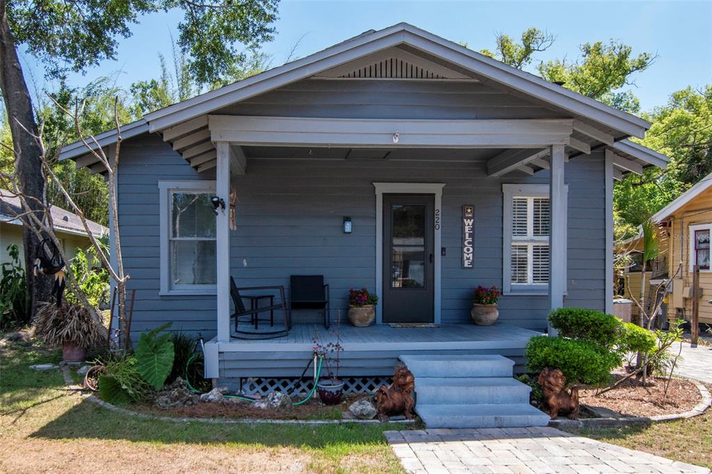A gray, single-story house with a front porch, steps, and a paved walkway — 220 W FERN STREET, TAMPA, FL