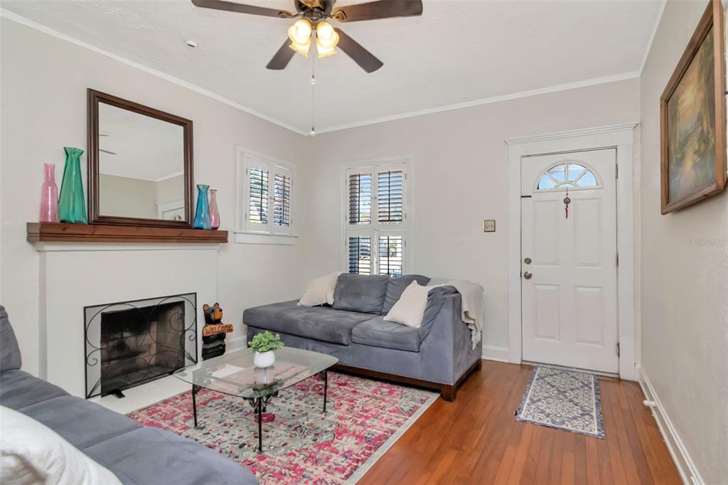 A living room features a fireplace, a blue sofa, a glass coffee table, and hardwood floors — 220 W FERN STREET, TAMPA, FL