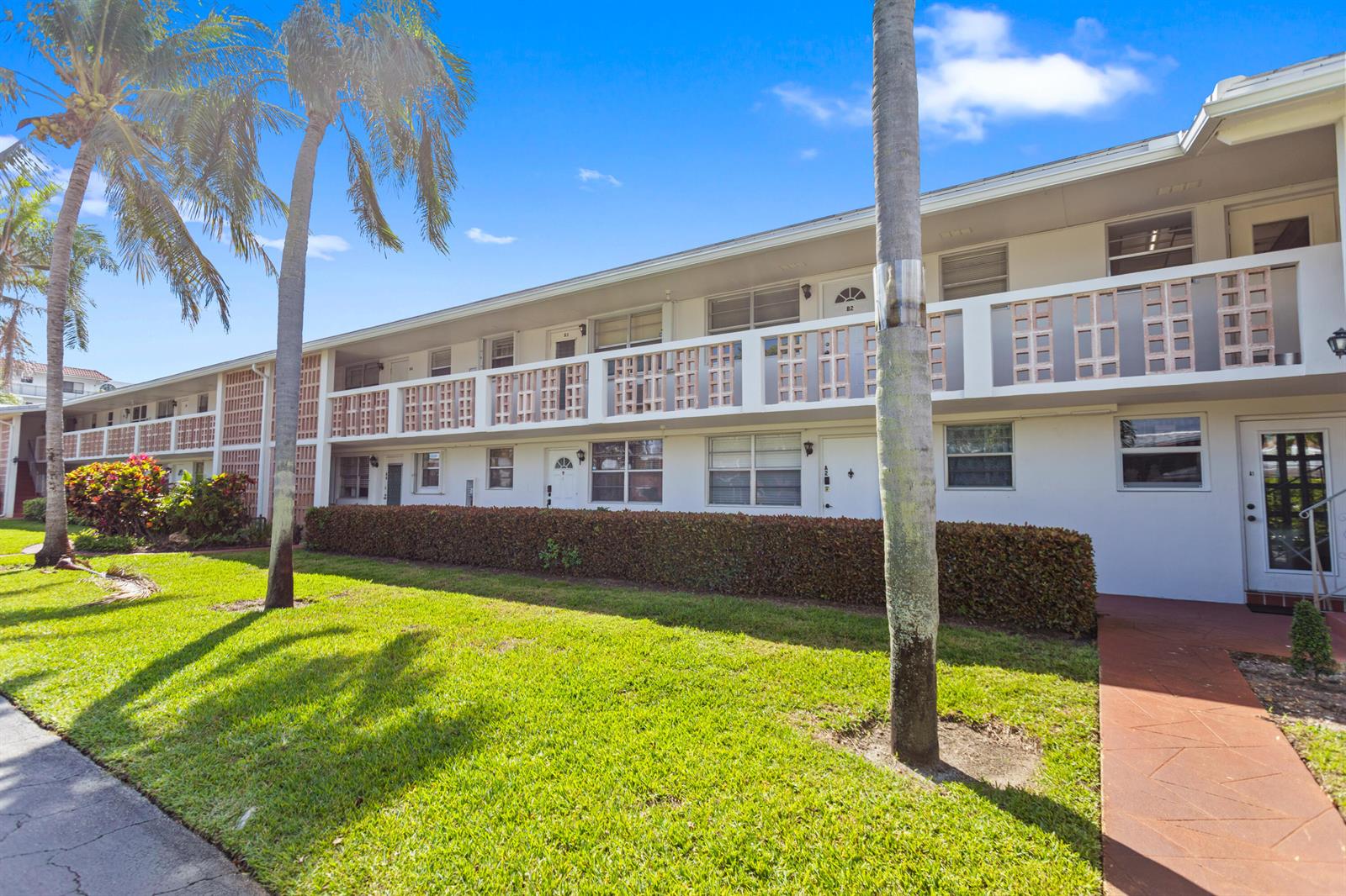 A two-story apartment building with a white exterior, balconies, and a manicured lawn — 30 SE 13th Street # B3, Boca Raton FL 33432, BOCA RATON, FL