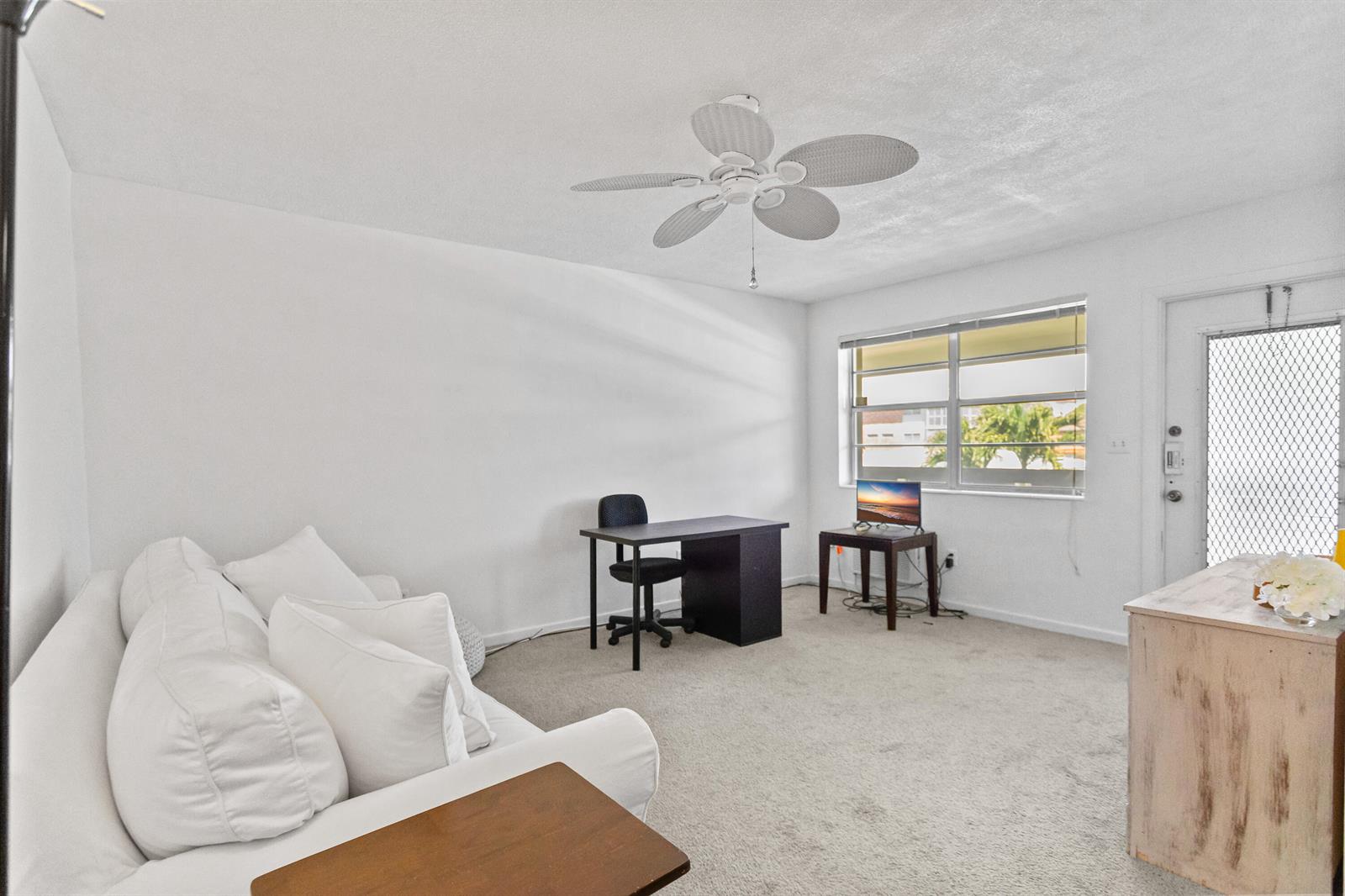 A living room features white walls, carpeted floors, a ceiling fan, and a desk area — 30 SE 13th Street # B3, Boca Raton FL 33432, BOCA RATON, FL