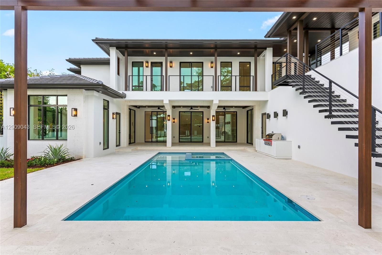 A modern two-story house features a rectangular swimming pool and an external staircase — 730 Zamora Ave, Coral Gables FL 33134, CORAL GABLES, FL