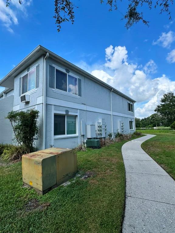 A two-story light blue apartment building sits next to a concrete sidewalk and grass — 4140 DOLPHIN DRIVE, TAMPA, FL