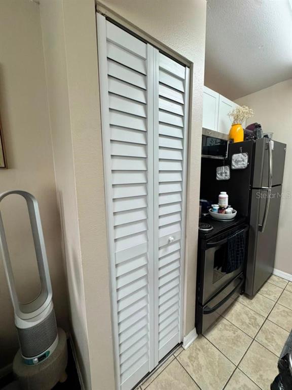 A white louvered closet door stands next to a kitchen with a stainless steel stove — 4140 DOLPHIN DRIVE, TAMPA, FL
