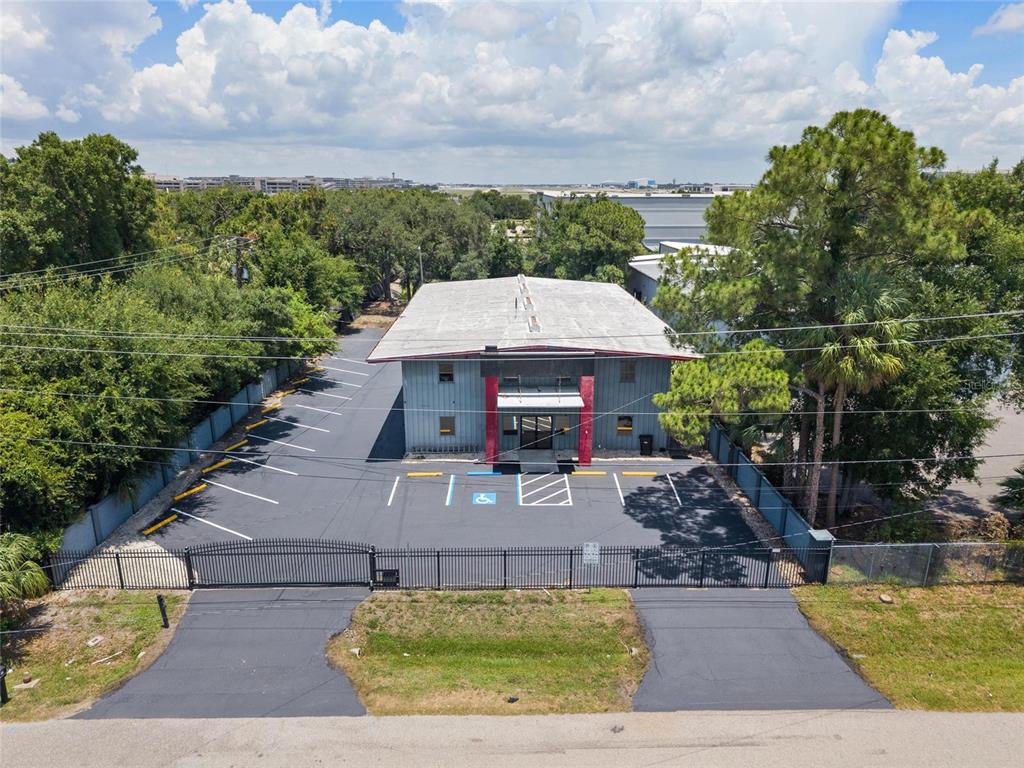 An aerial view shows a two-story commercial building with a parking lot and gated entrance — 5021 W NASSAU STREET, TAMPA, FL