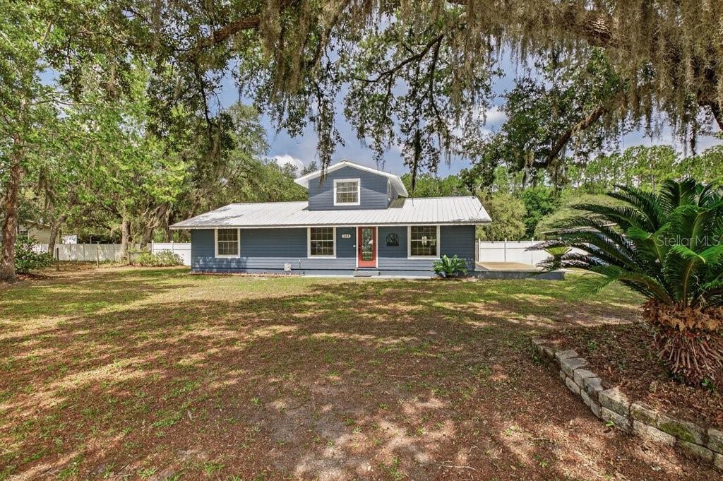 A blue, single-story house with a metal roof and a central dormer window — 121 DAREN DRIVE, PALATKA, FL