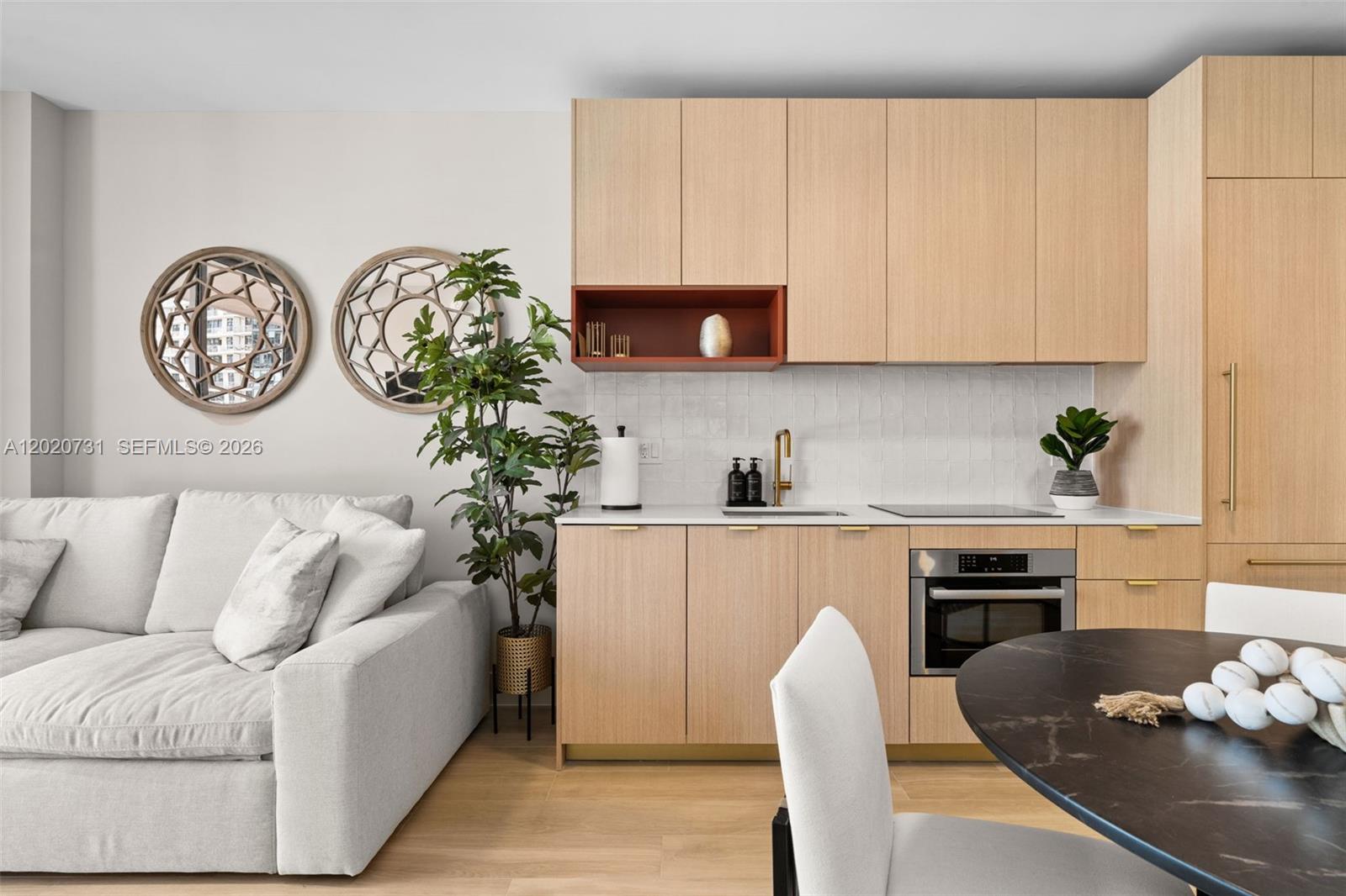 A modern kitchen features light wood cabinetry, a terracotta open shelf, and a white backsplash — 90 NE 32 # 905, Miami FL 33137, MIAMI, FL
