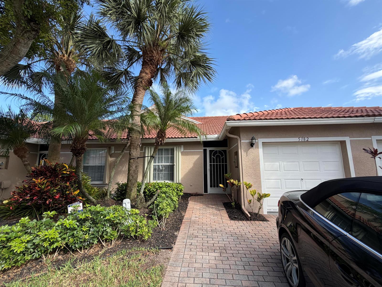 A single-story house with a tiled roof, palm trees, and a brick walkway — 5182 Toscana Trail, Boynton Beach FL 33437, BOYNTON BEACH, FL