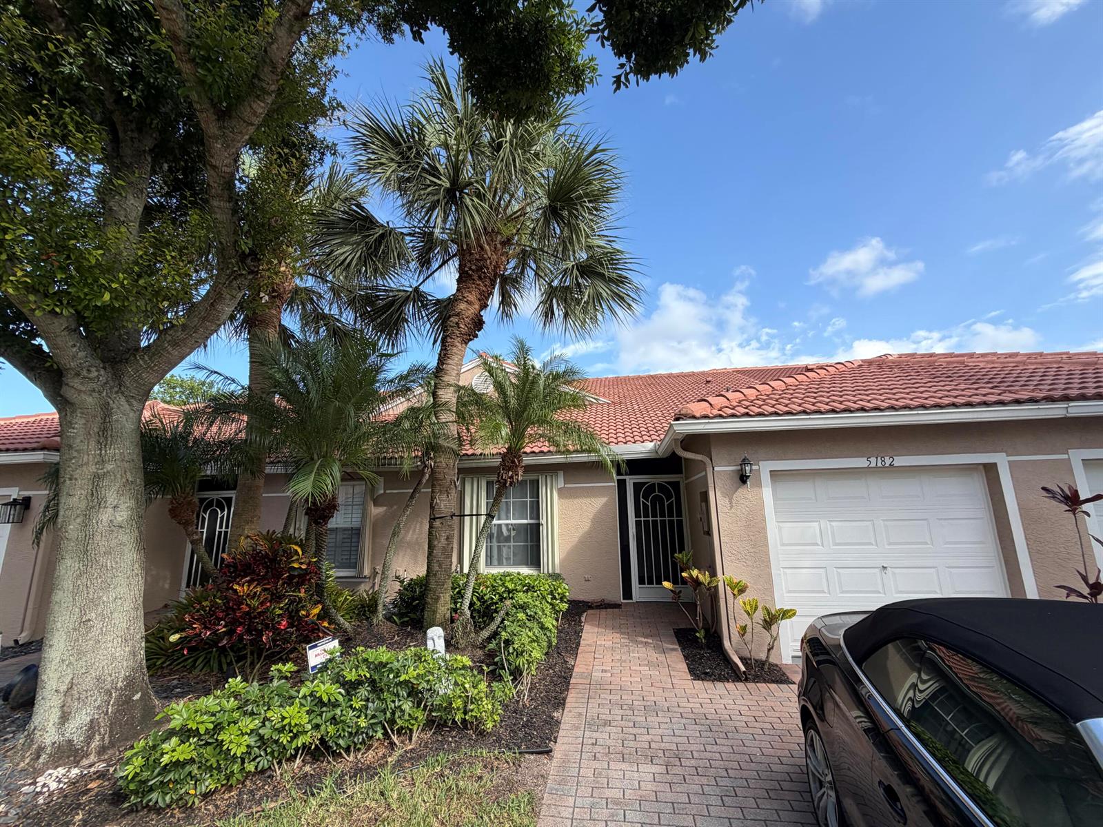 A single-story house with a tiled roof, palm trees, and a brick walkway — 5182 Toscana Trail, Boynton Beach FL 33437, BOYNTON BEACH, FL