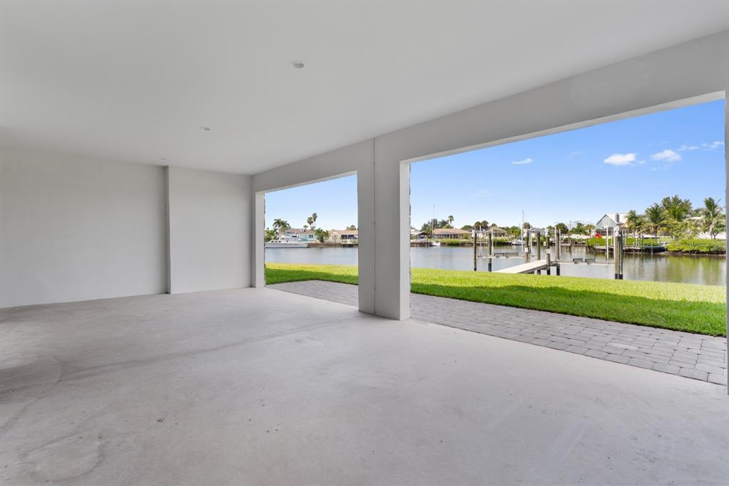 An unfinished concrete patio overlooks a canal with a private boat dock and lawn — 772 GRAN KAYMEN WAY, APOLLO BEACH, FL