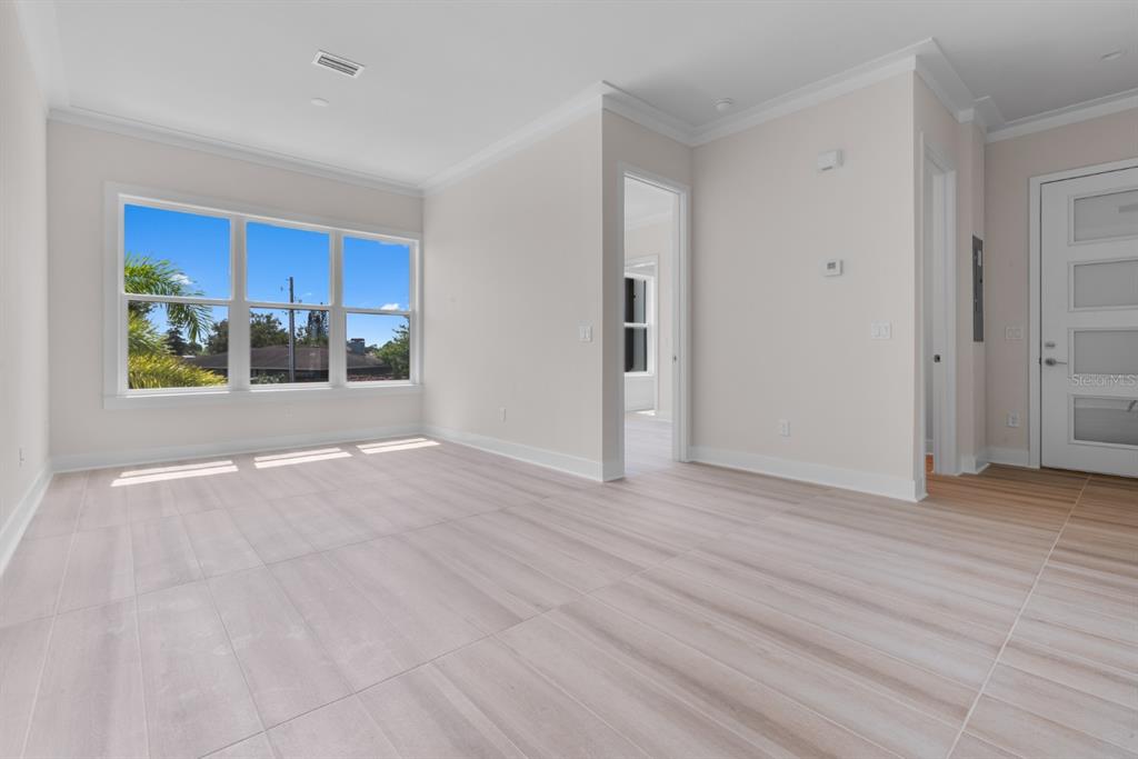 An empty room with light-colored tile flooring, white walls, and a large window — 772 GRAN KAYMEN WAY, APOLLO BEACH, FL