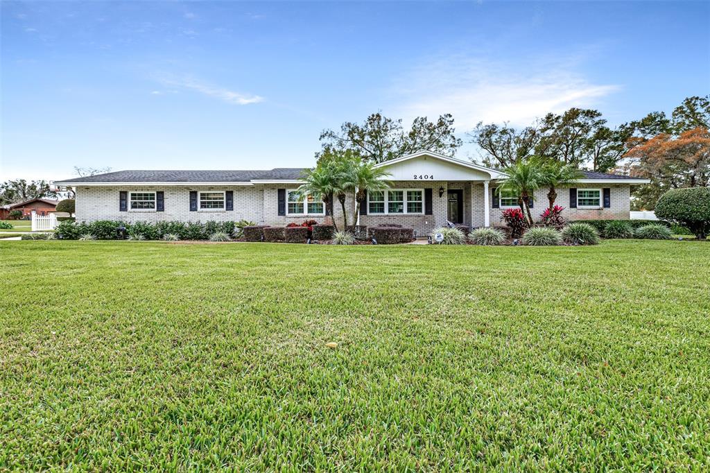 A single-story brick house with a large front lawn and a covered entryway — 2404 GIBSONIA GALLOWAY ROAD, LAKELAND, FL