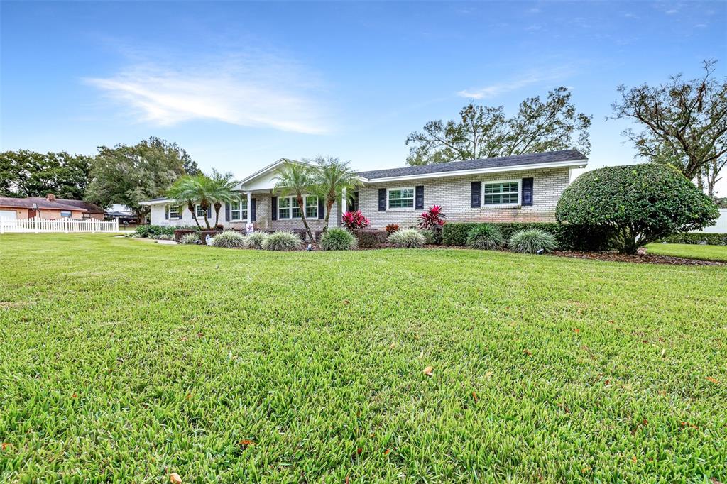 A single-story brick house with a large front lawn and a white picket fence — 2404 GIBSONIA GALLOWAY ROAD, LAKELAND, FL
