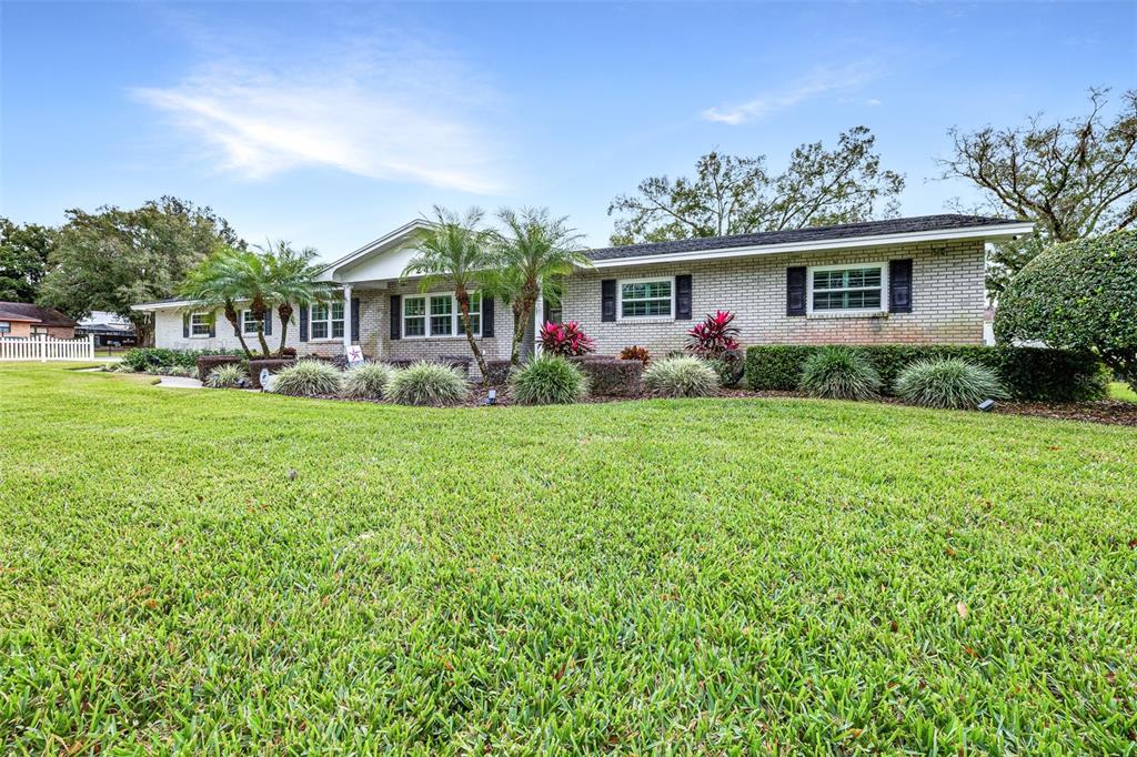 A single-story brick house with a large front lawn and manicured landscaping — 2404 GIBSONIA GALLOWAY ROAD, LAKELAND, FL