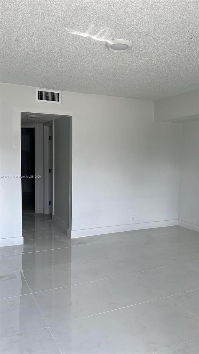 A room with white walls, light-colored tile flooring, and a recessed ceiling light — 6051 Arthur St # 14, Hollywood FL 33024, HOLLYWOOD, FL