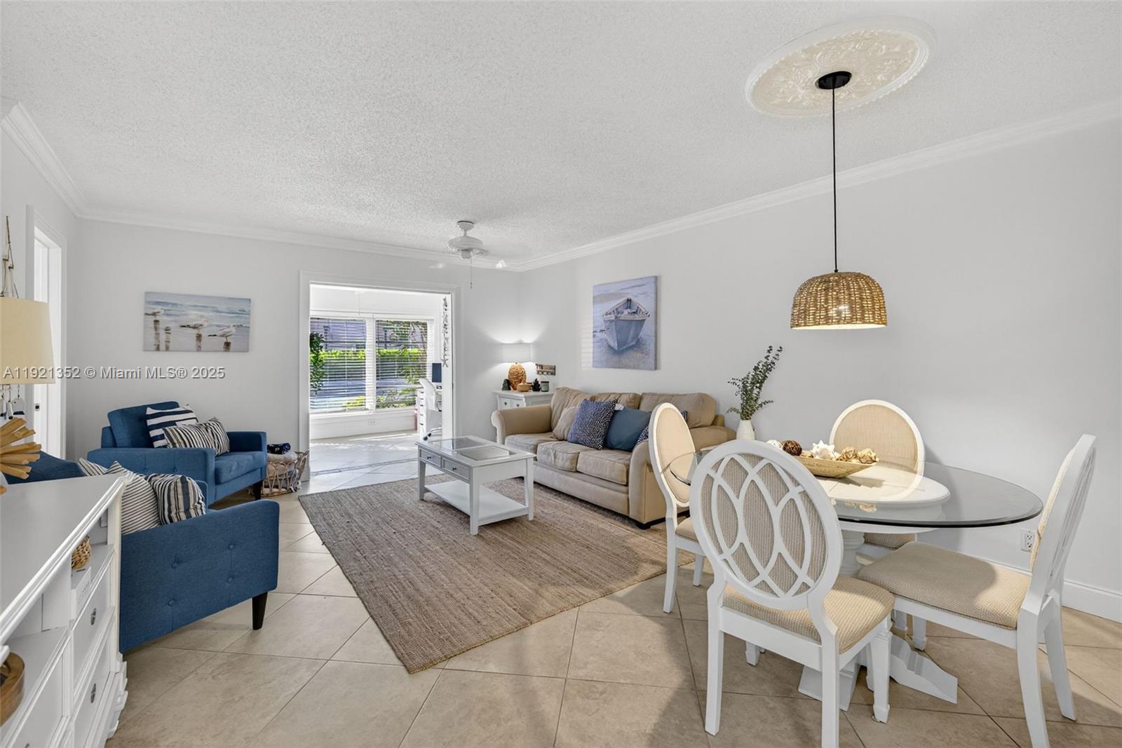 A living and dining area features tile floors, a neutral sofa, blue chairs, and furniture — 5681 SW 2nd Ct # 117, Margate FL 33068, MARGATE, FL