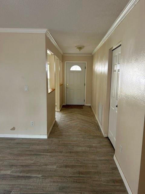 A hallway with wood-look tile flooring leads to a white front door — 1404 SANDALWOOD DRIVE, DUNEDIN, FL