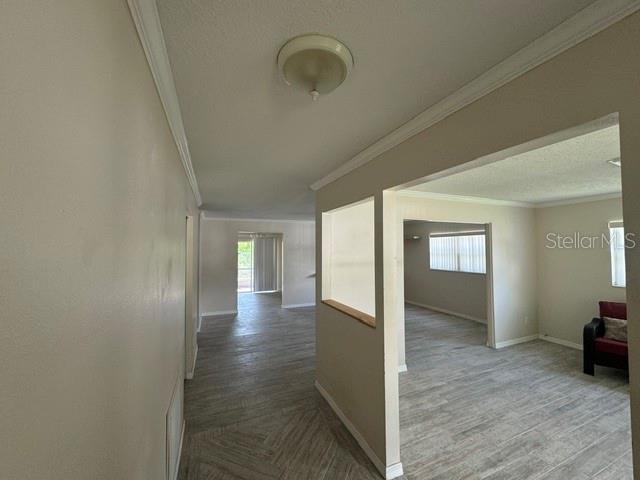 An interior view shows a living area with light-colored tile flooring and a pass-through window — 1404 SANDALWOOD DRIVE, DUNEDIN, FL