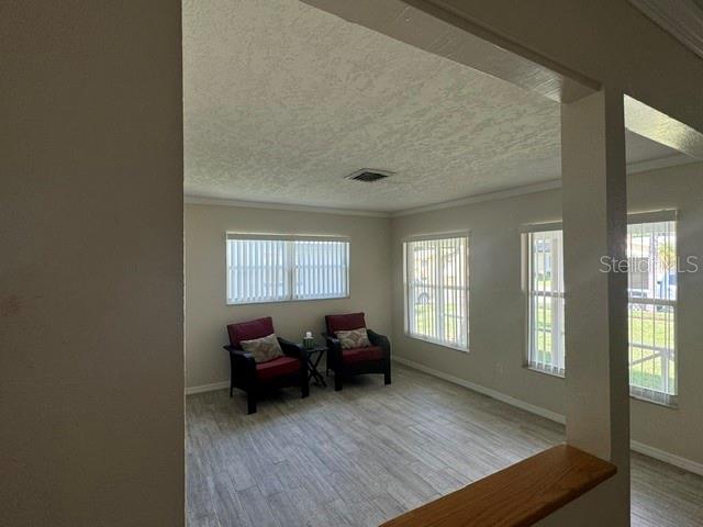 A room with light-colored tile flooring, two armchairs, and windows with vertical blinds — 1404 SANDALWOOD DRIVE, DUNEDIN, FL
