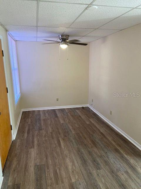 An empty room features wood-look flooring, a ceiling fan, and a window with blinds — 111 S NEWPORT AVENUE UNIT 18, TAMPA, FL
