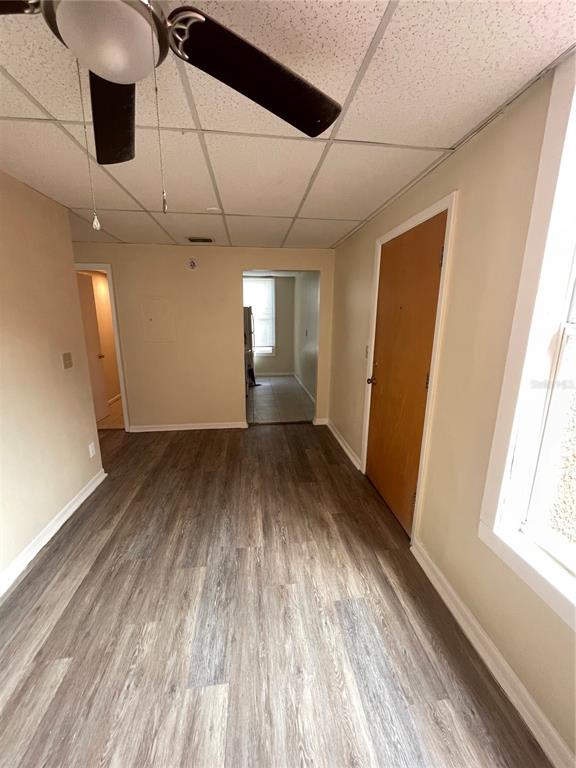 A room with wood-look flooring, a drop ceiling, a ceiling fan, and two doorways — 111 S NEWPORT AVENUE UNIT 18, TAMPA, FL
