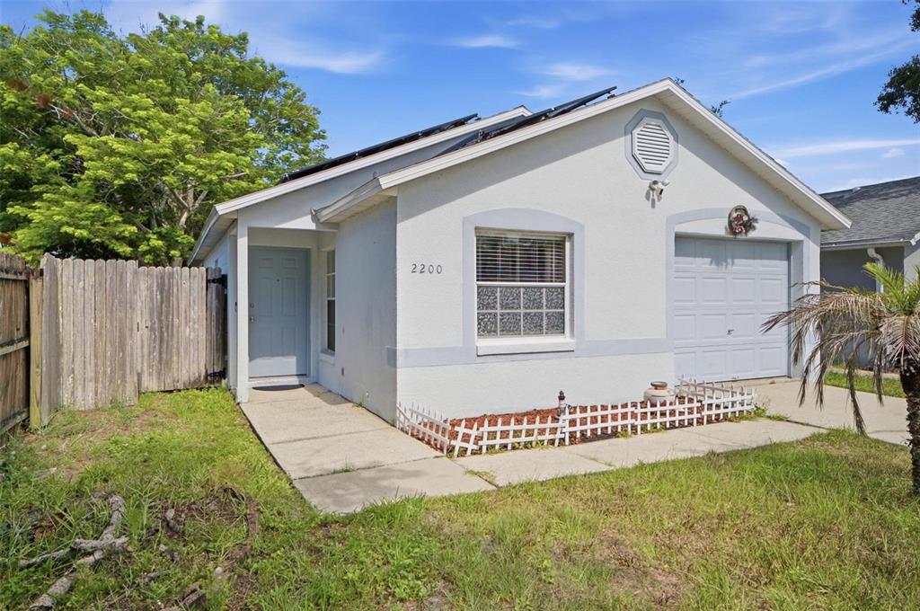 A single-story house with a light-colored stucco exterior, a front door, and a garage — 2200 ROSE BROOK COURT, ORLANDO, FL