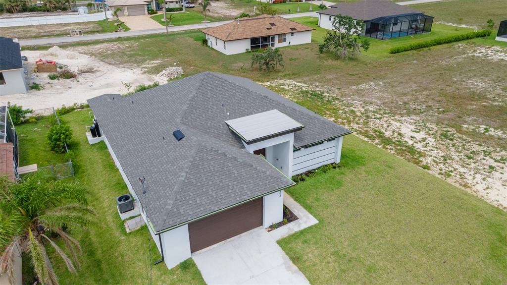 An aerial view of a single-story house with a gray shingled roof and brown garage — 1638 NW 36TH PLACE, CAPE CORAL, FL