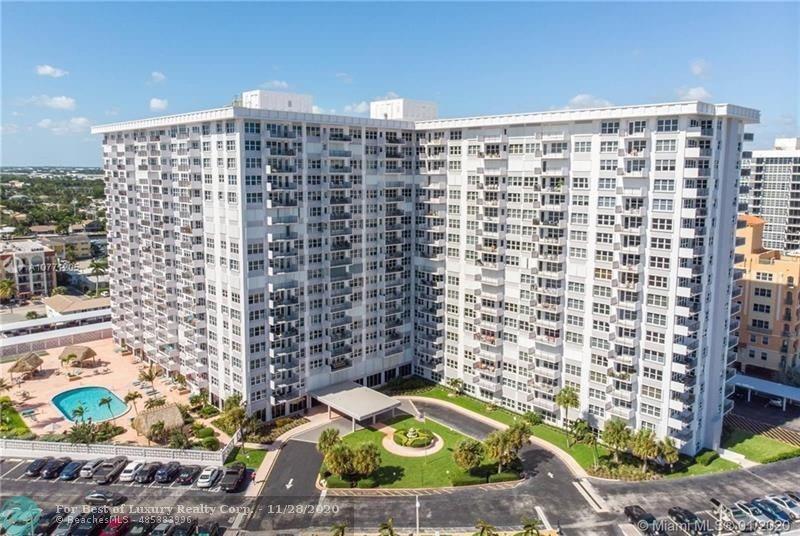 An aerial view of a large, multi-story white apartment building with an outdoor swimming pool — 405 N Ocean Boulevard # 1123, Pompano Beach FL 33062, POMPANO BEACH, FL