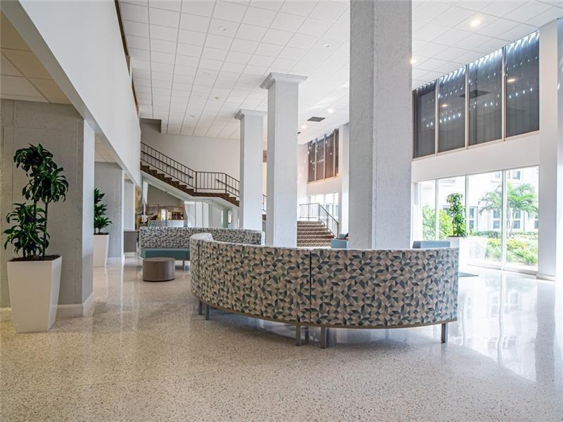 A fitness center with various exercise machines, a weight bench, and floor-to-ceiling windows — 405 N Ocean Boulevard # 1123, Pompano Beach FL 33062, POMPANO BEACH, FL