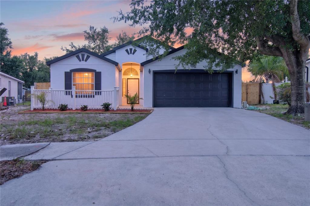 A single-story house with a white exterior, black garage door, and a front porch railing — 314 RIDGE COURT, APOPKA, FL