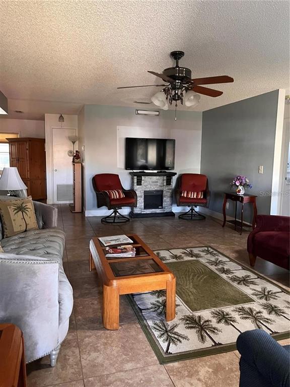A living room features tile floors, a ceiling fan, a fireplace, and a television — 8757 SW 97TH LANE ROAD UNIT C, OCALA, FL