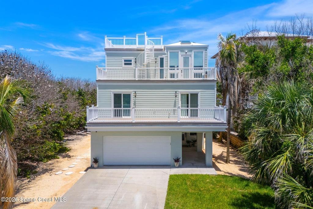 A three-story light green house features multiple balconies, a garage, and a rooftop deck — 6105 S HIGHWAY A1A, MELBOURNE BEACH, FL