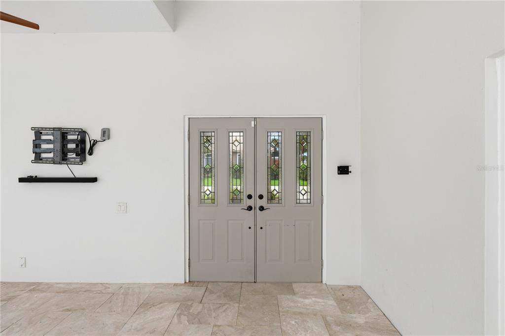 An aerial view of a single-story house with a tiled roof, driveway, and backyard lake — 309 S STONE BRIAR CREEK DRIVE, VENICE, FL
