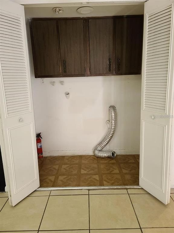 A laundry closet with upper cabinets, a dryer vent hose, and a fire extinguisher — 2222 SILVER PINES PLACE UNIT 902, ORLANDO, FL