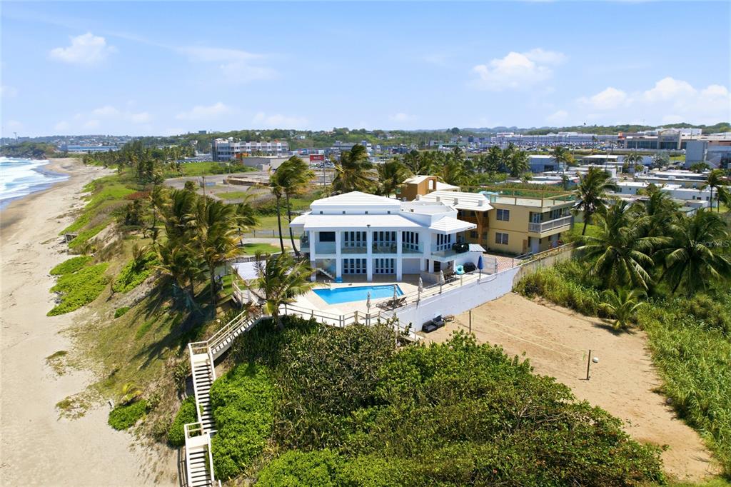 An aerial view of a white multi-story house with a pool overlooking a sandy beach — MARFIL ST. TESORO DEL MAR IN LAS PALMAS, HATILLO, PR