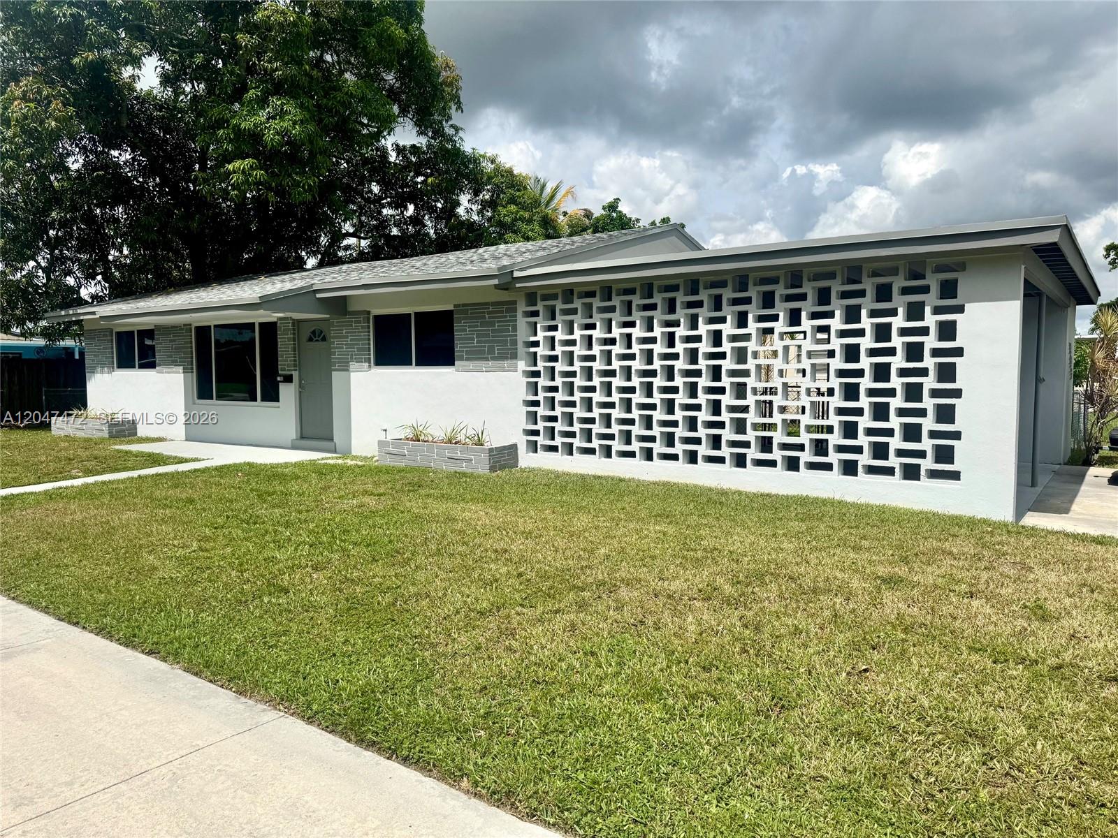 A single-story house features a gray and white exterior with a decorative breeze block wall — 2150 N 66th Ave, Hollywood FL 33024, HOLLYWOOD, FL