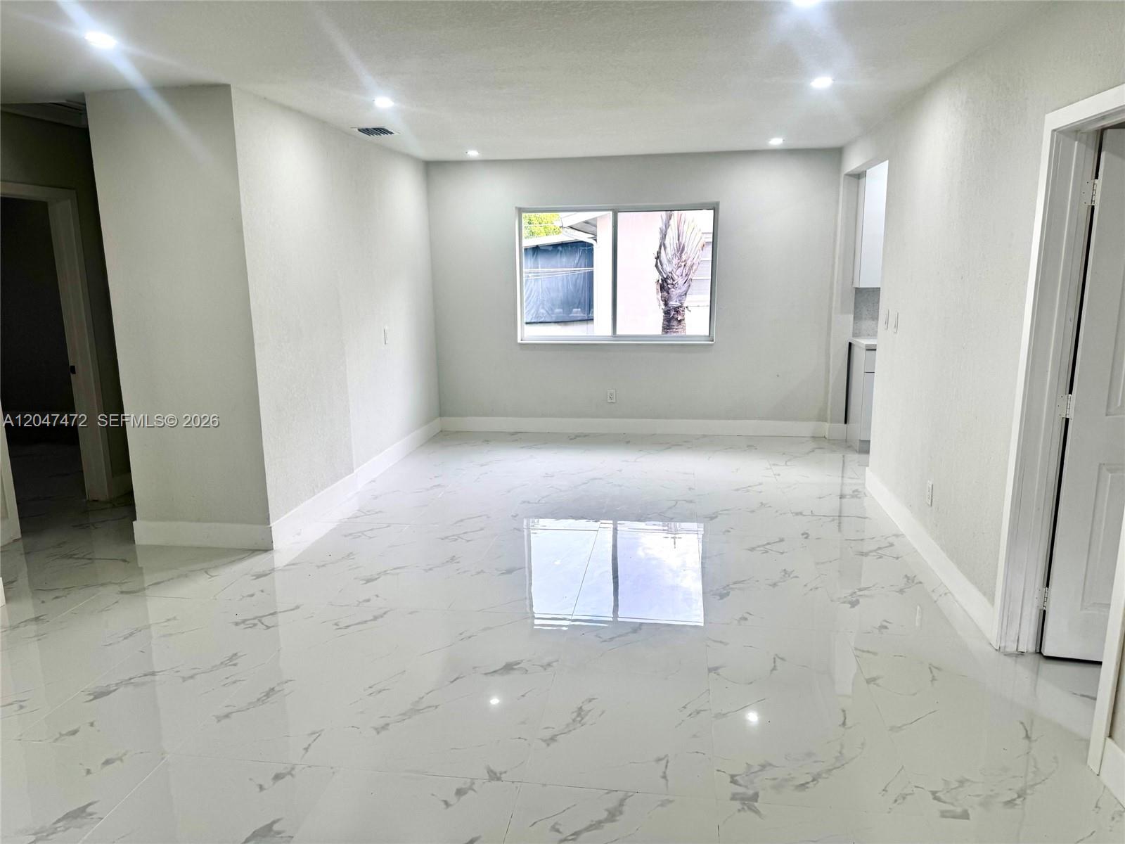A single-story house features a gray stone-patterned facade, a decorative breeze block wall, and lawn — 2150 N 66th Ave, Hollywood FL 33024, HOLLYWOOD, FL