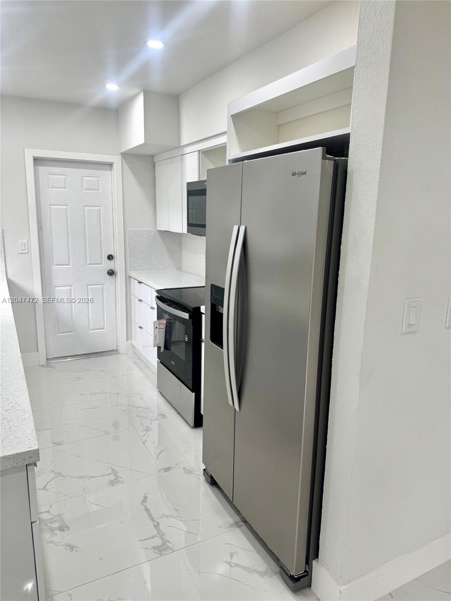 A single-story house features a decorative concrete block wall, a carport, and a grassy lawn — 2150 N 66th Ave, Hollywood FL 33024, HOLLYWOOD, FL