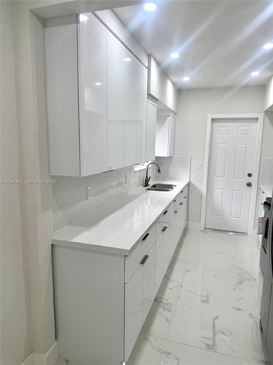 A single-story house features a decorative breeze block wall and gray exterior accents — 2150 N 66th Ave, Hollywood FL 33024, HOLLYWOOD, FL