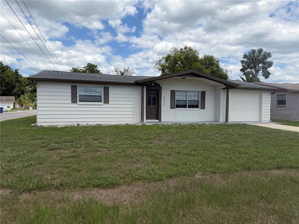 A single-story house with white siding, a brick facade, and an attached garage — 3452 COLUMBUS DRIVE, HOLIDAY, FL