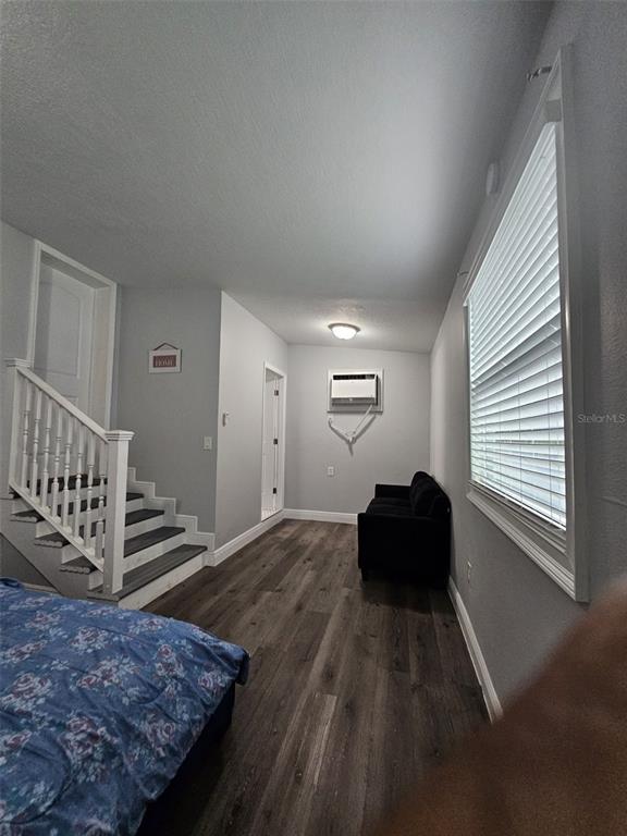 A bedroom features wood-look flooring, a staircase with white railings, and a window with blinds — 6928 SALINAS DRIVE, ORLANDO, FL