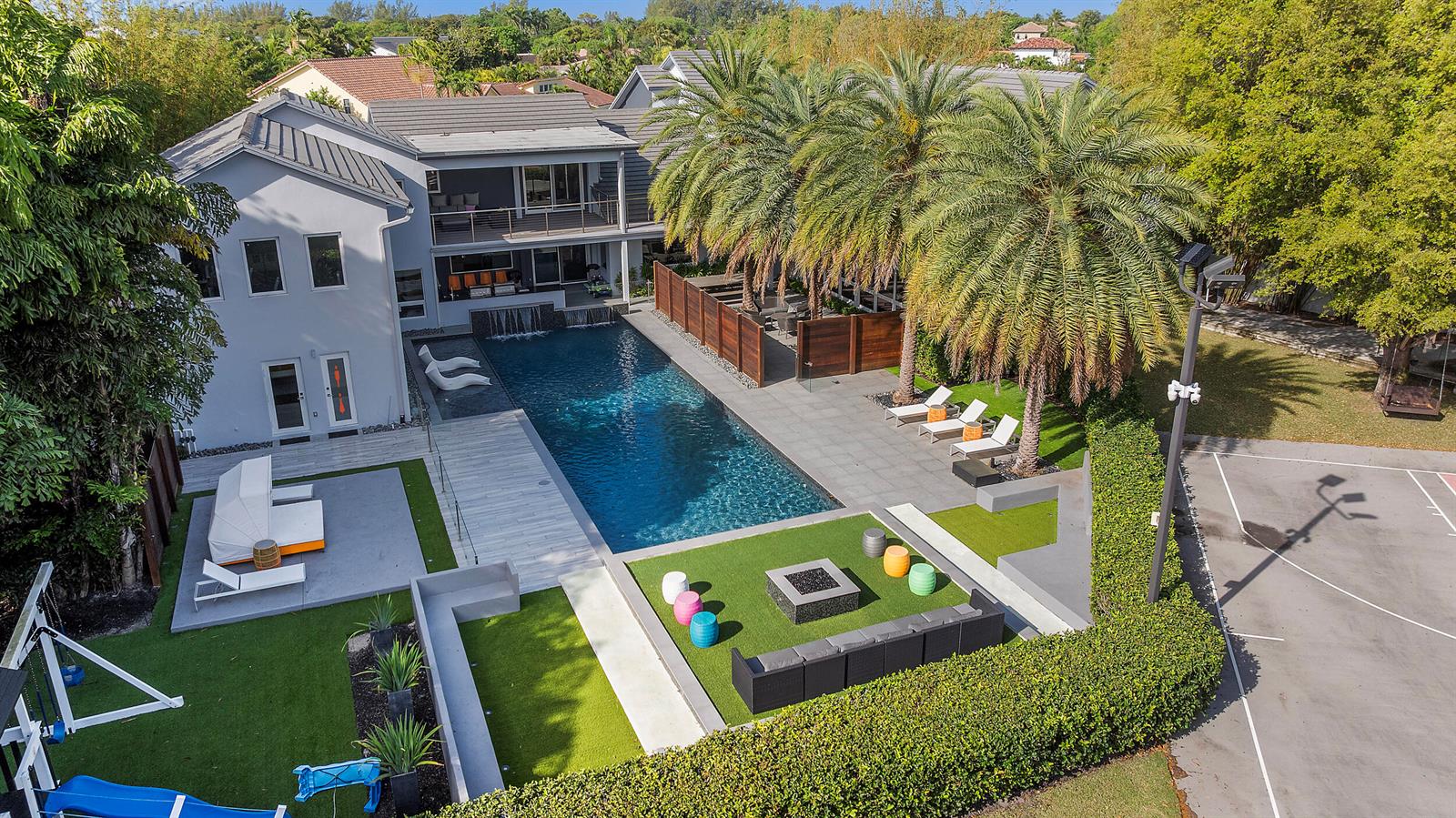 An aerial view of a backyard featuring a swimming pool, patio, fire pit, and landscaping — 7047 San Sebastian Circle, Boca Raton FL 33433, BOCA RATON, FL