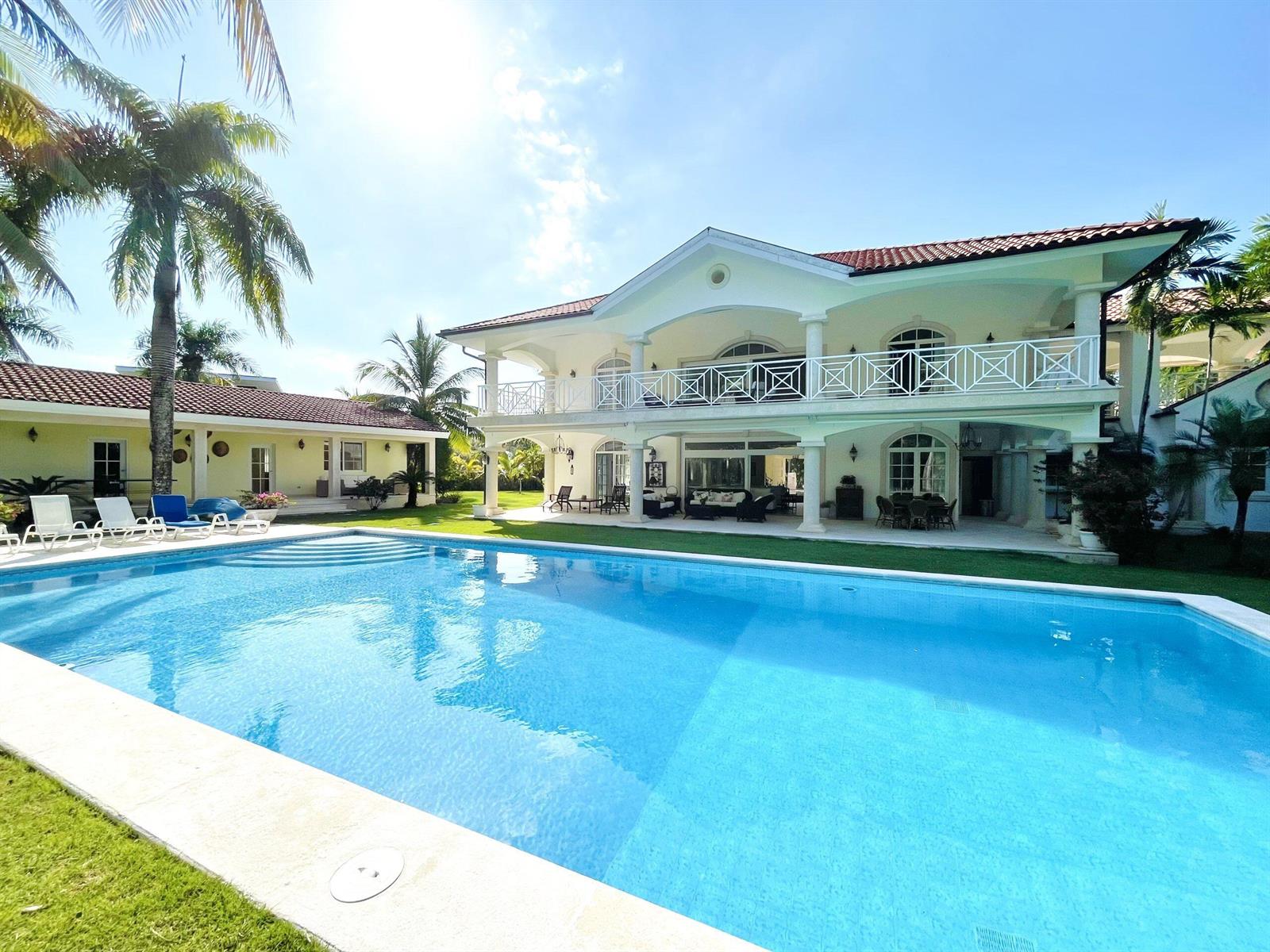 A two-story white house with a large swimming pool and palm trees in the yard — 123 Sea Horse Ranch, FL