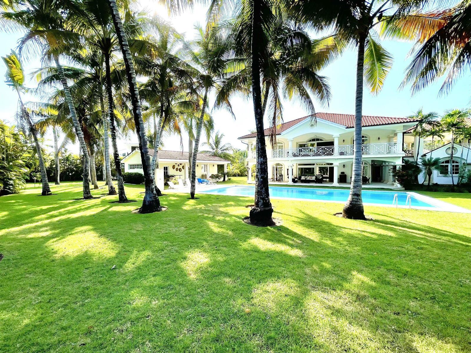 A large two-story house with a swimming pool and palm trees on a grassy lawn — 123 Sea Horse Ranch, FL