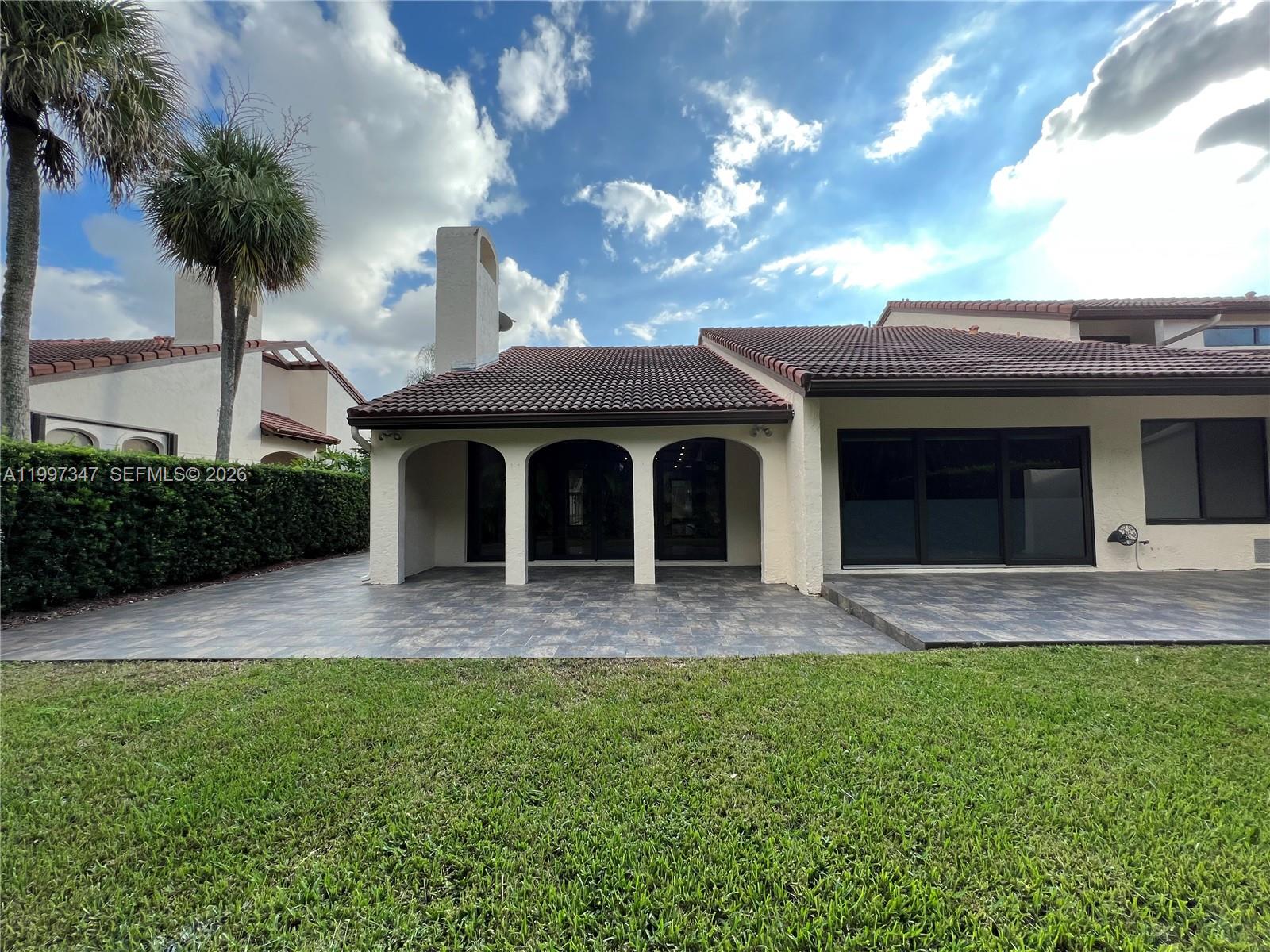 A living room features gray tile floors, a stainless steel fireplace, and exposed wood beams — 9331 NW 48th Doral Ter # 0, Doral FL 33178, DORAL, FL